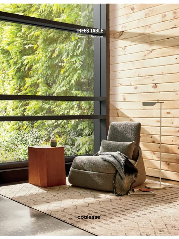 Modern office interior with large windows, wooden walls, comfortable lounge chair, and indoor plants.